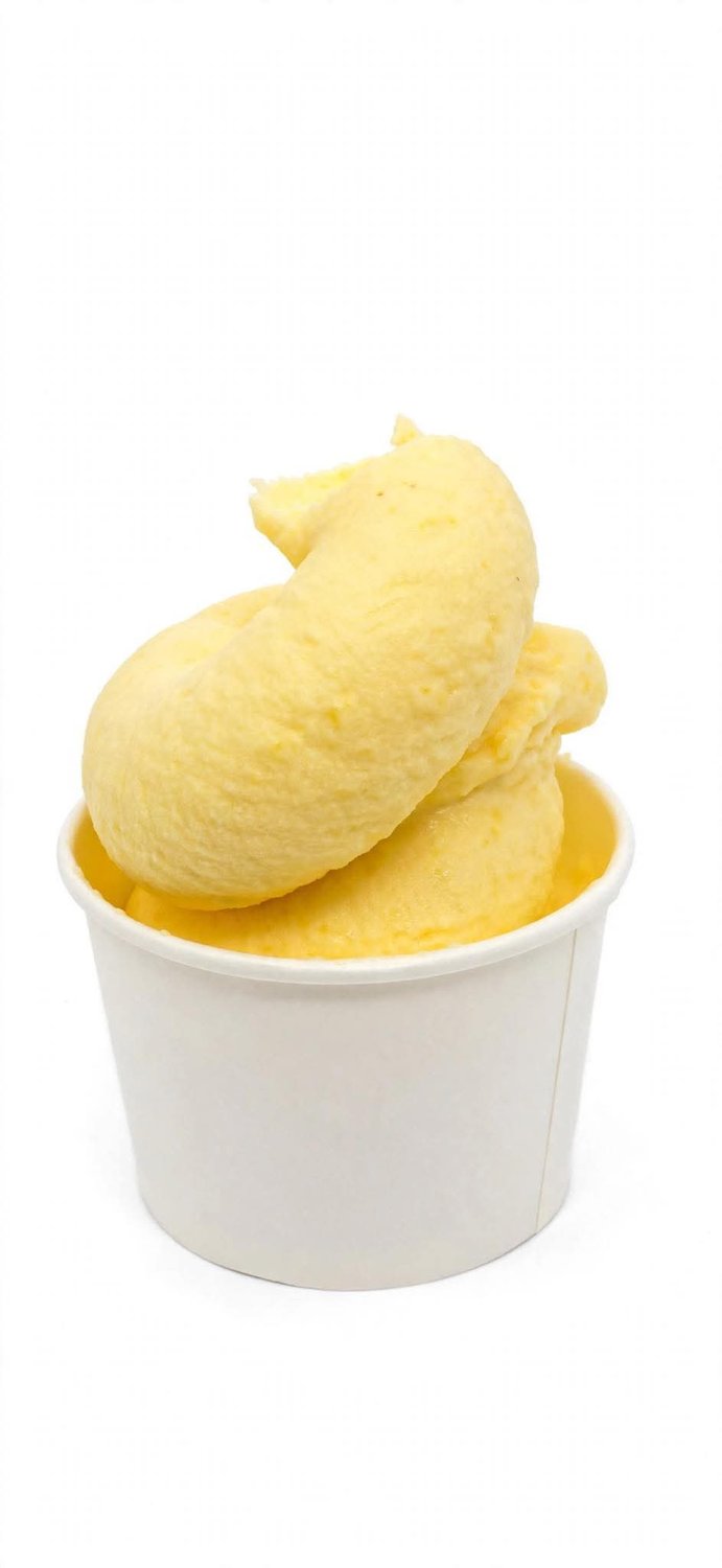 Yellow fruit soft serve in a white cup
