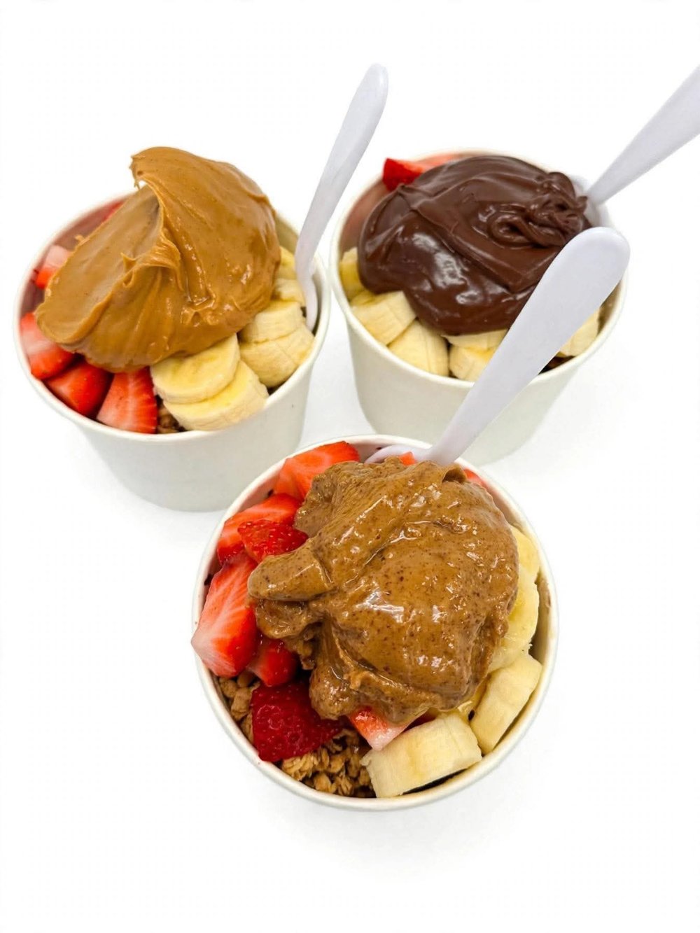Three acai bowls with nut butter toppings
